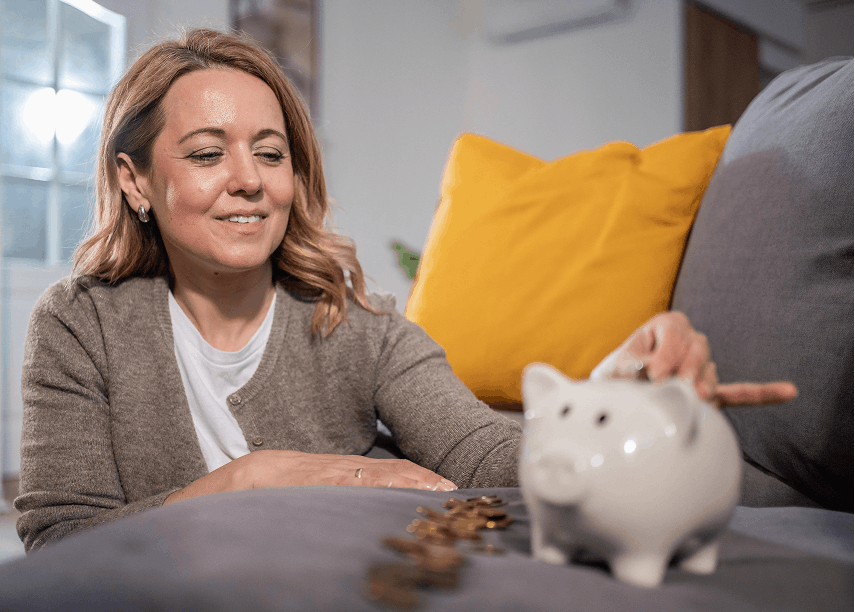 Vrouw bij spaarpot en munten